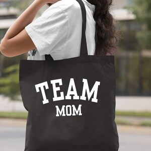 May include: Black canvas tote bag with white text that reads "TEAM MOM".