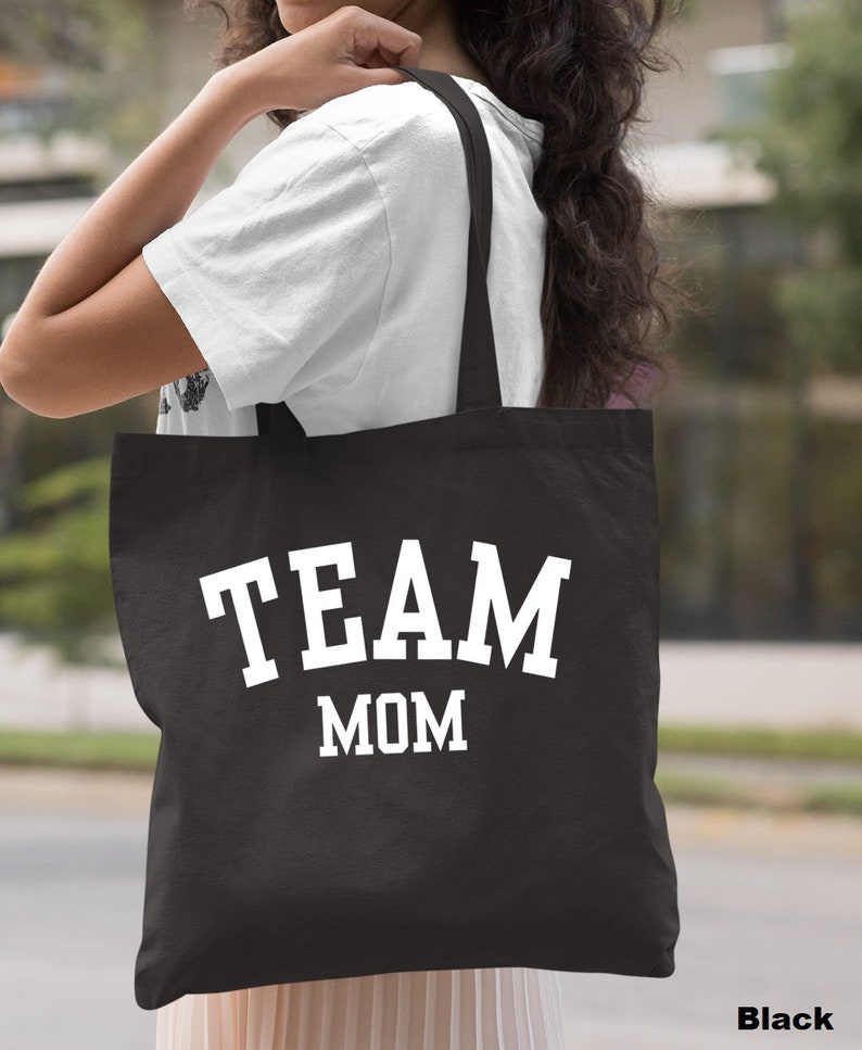 May include: Black canvas tote bag with white text that reads "TEAM MOM".
