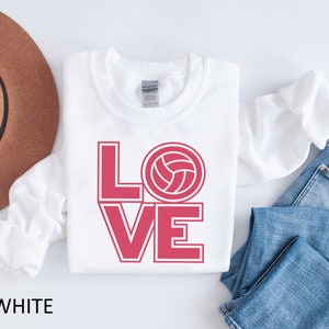 May include: White sweatshirt with the word "LOVE" in red with a volleyball graphic in the "O".