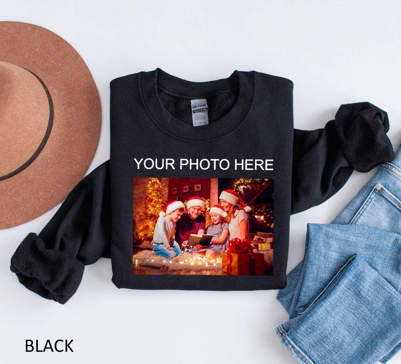 May include: Black sweatshirt with a photo of a family in front of a Christmas tree. The text "YOUR PHOTO HERE" is printed above the photo.