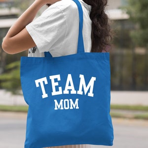 May include: A royal blue tote bag with white text that reads "TEAM MOM".
