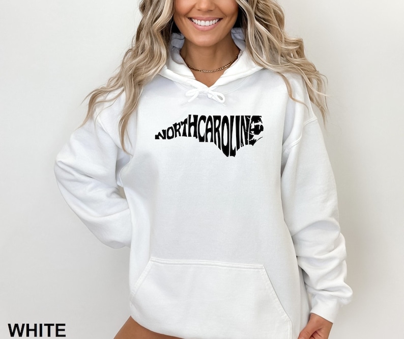 K&ouml;nnte beinhalten: Wei&szlig;er Kapuzenpullover mit einer schwarzen Umrandung des Bundesstaates North Carolina, wobei das Wort "NORTH CAROLINA" innerhalb der Umrandung ausgeschrieben ist.