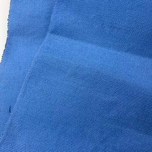Può includere: Primo piano di due pezzi di tessuto blu brillante. Il tessuto ha un aspetto strutturato e a coste. Il materiale è piegato, mostrando le variazioni di consistenza e colore.