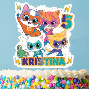 Puede incluir: Un adorno para pastel con cuatro gatos de dibujos animados vestidos de superhéroes, con un ratón, el número 5 y el nombre "KRISTINA".