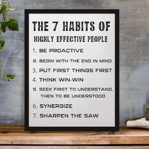 May include: A black and white framed print with the text "THE 7 HABITS OF HIGHLY EFFECTIVE PEOPLE" and a list of seven habits: "1. BE PROACTIVE", "2. BEGIN WITH THE END IN MIND", "3. PUT FIRST THINGS FIRST", "4. THINK WIN-WIN", "5. SEEK FIRST TO UNDERSTAND, THEN TO BE UNDERSTOOD", "6. SYNERGIZE", "7. SHARPEN THE SAW".