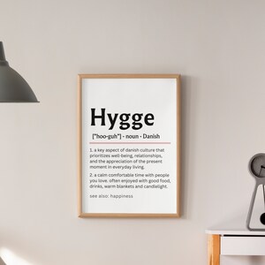 May include: A black and white printable wall art print with the definition of the Danish word "Hygge" which means a feeling of coziness and contentment. The definition includes the pronunciation of the word and a description of the concept.