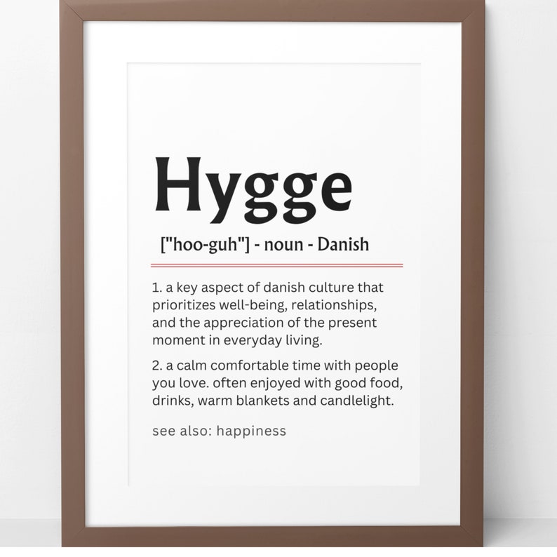 May include: A printable definition of the Danish word "Hygge" pronounced "hoo-guh" meaning a key aspect of Danish culture that prioritizes well-being, relationships, and the appreciation of the present moment in everyday living. It also describes a calm comfortable time with people you love, often enjoyed with good food, drinks, warm blankets and candlelight.  The definition also includes the phrase "see also: happiness".