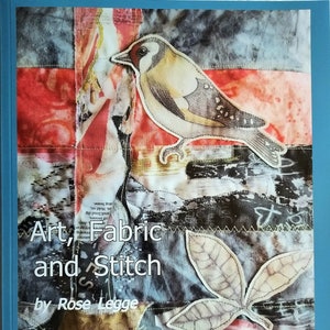 May include: Book cover with the title "Art, Fabric and Stitch" by Rose Legge. The cover features a collage of fabric scraps with a bird, leaves, and text.