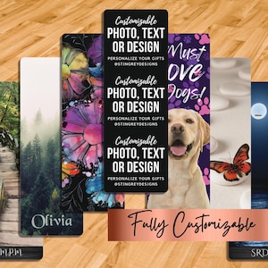 7 mats laid out on a gym floor. Main is black with white text that says, Customizable Photo, Text or Design. Personalize your gifts at stingreydesigns 3x. 1 with photo of mountain stairs & script initials at the bottom over faux black wood, a misty forestscene with Olivia, line art flowers with watercolor splashes, Must love Dogs, paw prints and dog, butterfly and moon.