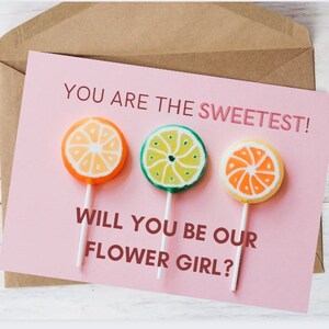May include: A pink card with the text "You are the sweetest!" and "Will you be our flower girl?" with three colorful lollipop images.
