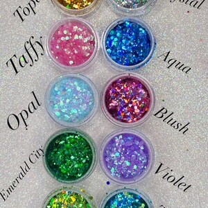 Può includere: Dieci piccoli barattoli di glitter, ognuno con un colore e un nome diverso. I colori includono topazo, caramella, opale, città smeraldo, giada, cristallo, acqua, blush, viola e turchese.