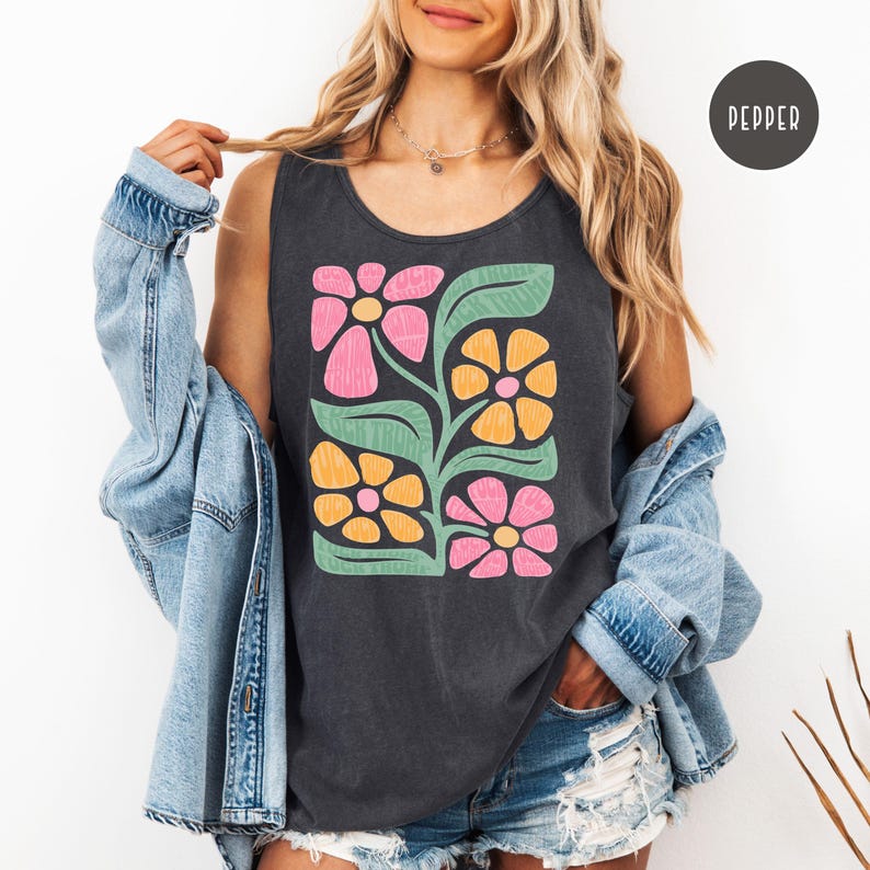 K&ouml;nnte beinhalten: Ein dunkelgraues &auml;rmelloses Tanktop mit einem grafischen Druck aus stilisierten rosa, gelben und gr&uuml;nen Blumen. Das Tanktop hat eine lockere Passform und einen runden Ausschnitt.