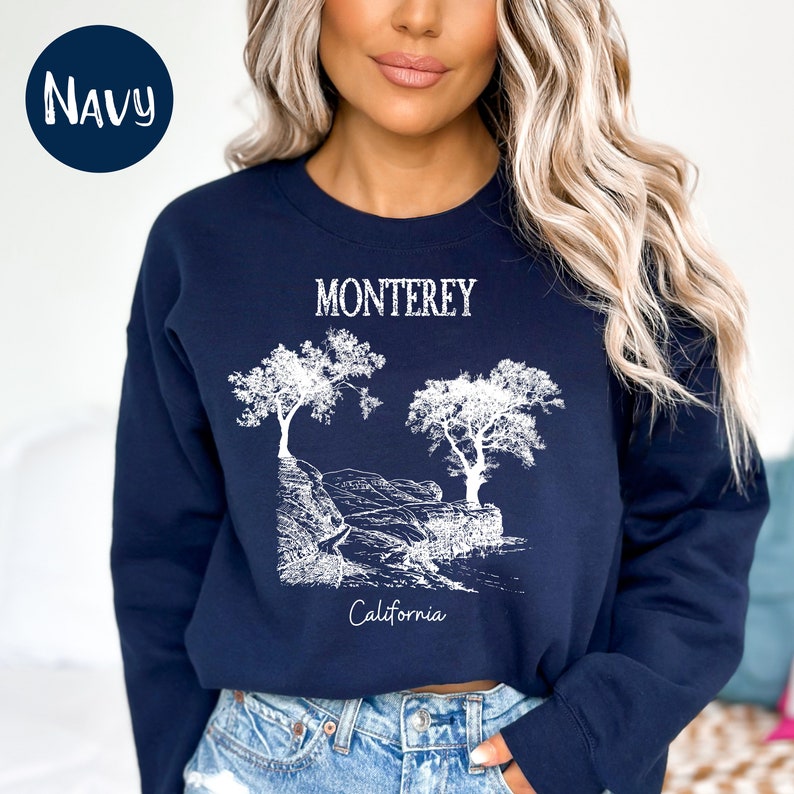 May include: Navy blue sweatshirt with a white graphic of trees and the text "Monterey California".