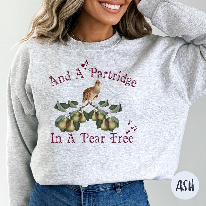 May include: A gray sweatshirt with a maroon print of a partridge in a pear tree. The text reads "And A Partridge In A Pear Tree".