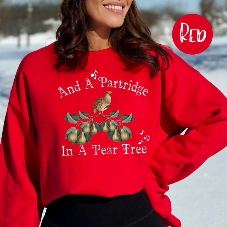 May include: Red sweatshirt with a white graphic of a partridge in a pear tree and the text "And A Partridge In A Pear Tree".