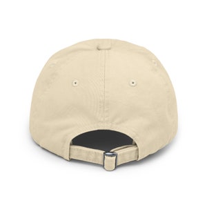 May include: A plain beige baseball cap with an adjustable strap in the back.