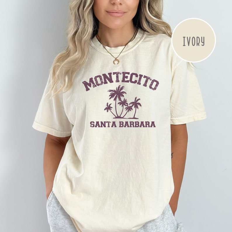 May include: A white t-shirt with a purple graphic print that says "Montecito Santa Barbara" with palm trees.