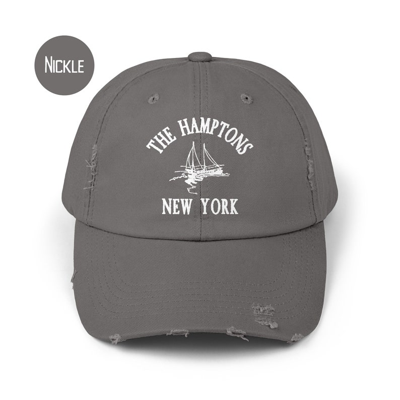May include: A gray distressed baseball cap with white embroidered text that reads "The Hamptons New York" and a sailboat graphic.