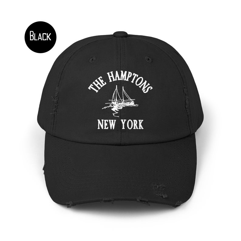 May include: Black distressed baseball cap with white embroidered text "The Hamptons New York" and a sailboat graphic.
