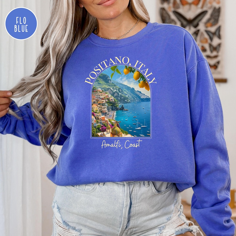 K&ouml;nnte beinhalten: Ein k&ouml;nigsblauer Pullover mit einem wei&szlig;en Aufdruck einer malerischen Aussicht auf Positano, Italien, mit dem Text "Positano, Italien" und "Amalfik&uuml;ste".