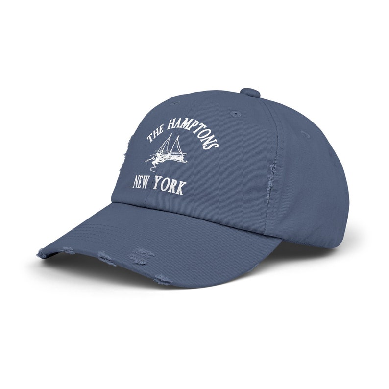 May include: A blue distressed denim baseball cap with white embroidery that reads "The Hamptons New York" and a sailboat graphic.
