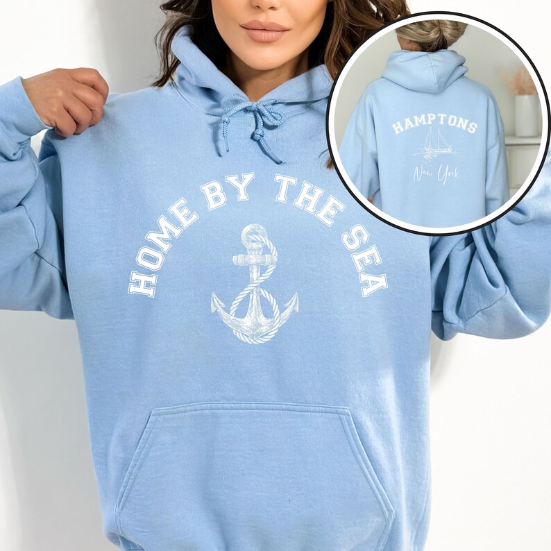 May include: Light blue hoodie with a white anchor and the text "Home by the Sea". The back of the hoodie has the text "Hamptons New York" with a sailboat graphic.