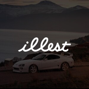 Peut inclure: Une voiture de sport blanche avec un aileron arrière garée sur une route, présentant le mot illest en grandes lettres cursives blanches centrées sur le véhicule. La voiture a des roues à cinq branches et un design élégant sur fond sombre.