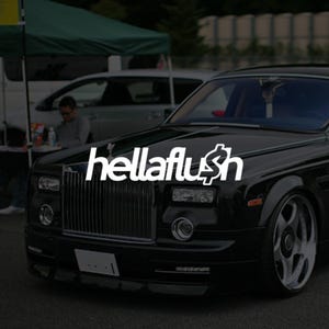 May include: A black luxury saloon featuring a prominent vertical chrome grille, rectangular headlights, and large multi-spoke wheels. The white text "hellaflush" is overlaid across the centre of the bonnet and front grille area of the vehicle.