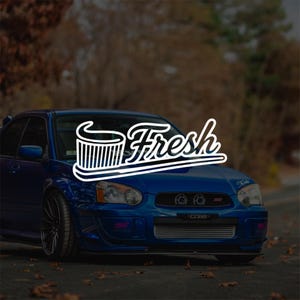 May include: A blue saloon car featuring a front-mounted intercooler and dark multi-spoke alloy wheels. A white graphic overlay displays a stylised toothbrush icon and the word Fresh in a cursive script, positioned centrally over the vehicle bonnet.