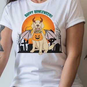 May include: White t-shirt with a graphic of a golden retriever dog wearing devil horns and wings, holding a jack-o-lantern. The text "Happy Howleween!" is above the dog.