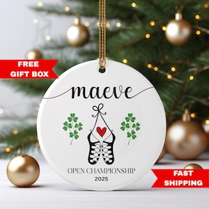 May include: White ceramic ornament with the name "maeve" in black script. Features a heart, shamrocks, and dancing shoes. The text "OPEN CHAMPIONSHIP 2025" is printed below. Includes a gold hanging cord.
