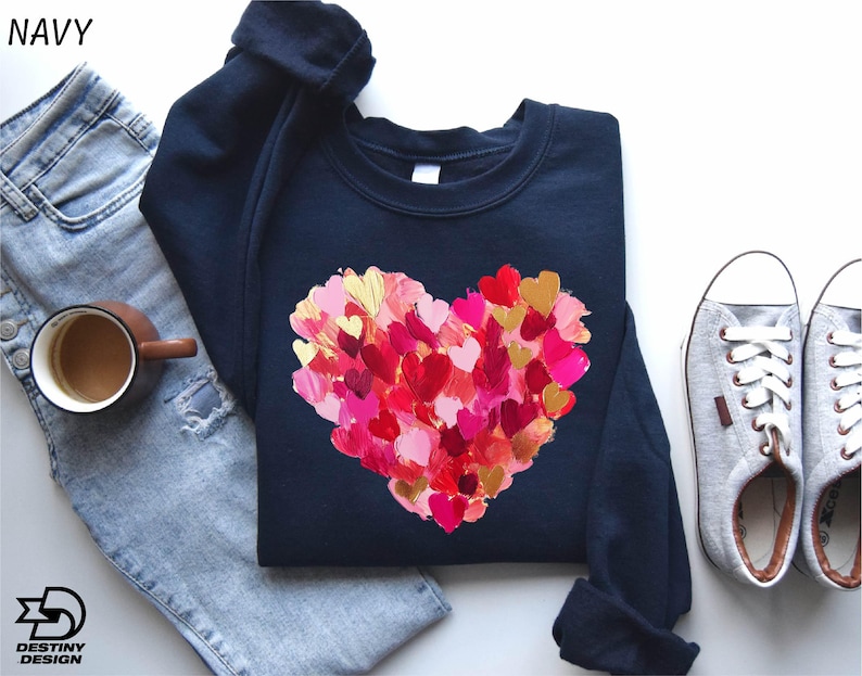 a t - shirt with a heart painted on it next to a pair of jeans