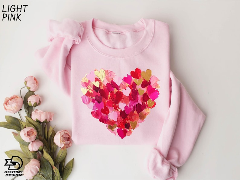 a pink sweater with hearts painted on it