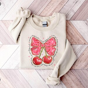a sweater with a bow and cherries on it