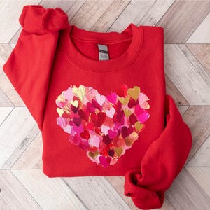 a red sweater with a heart made of hearts on it