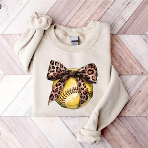 a sweater with a baseball and a bow on it