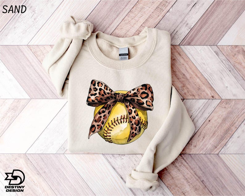 a sweater with a baseball and a bow on it
