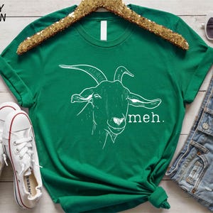 a green t - shirt with a picture of a goat on it