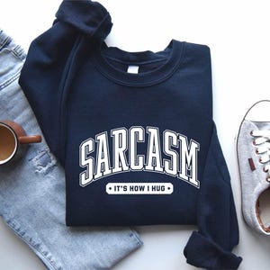 a pair of jeans, a sweatshirt, and a pair of sneakers
