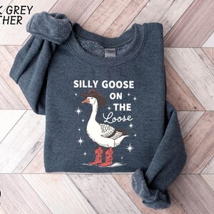 a sweater with a goose on it on a wooden floor