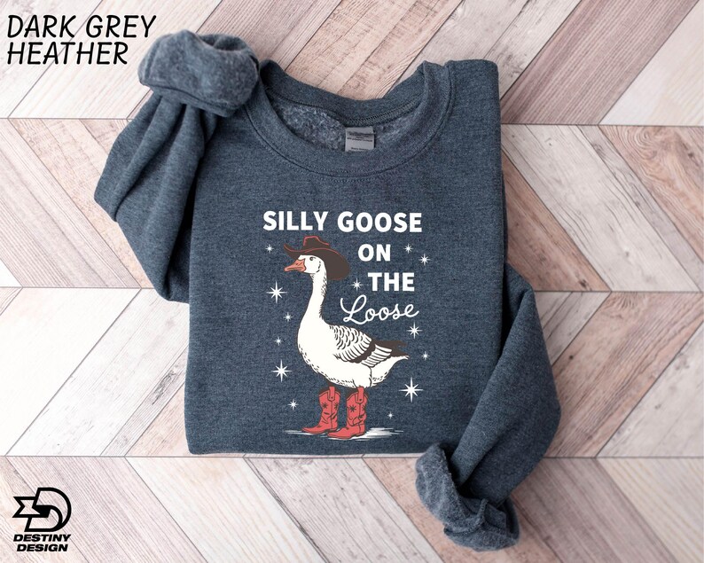 a sweater with a goose on it on a wooden floor