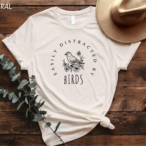 a white t - shirt with a bird on it