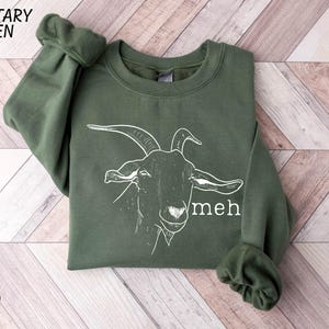 a green sweatshirt with a picture of a goat on it