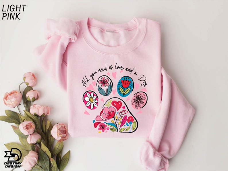 a pink sweater with a paw print on it