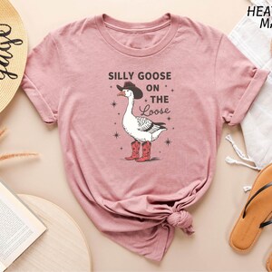 a pink shirt with a goose on the side