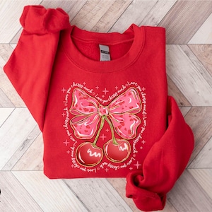 a red shirt with a bow and cherries on it