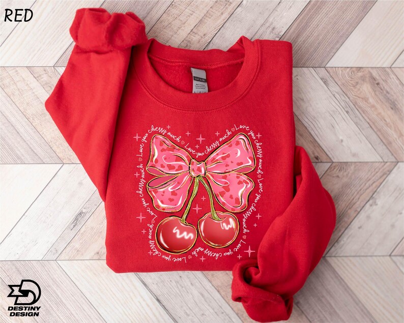 a red shirt with a bow and cherries on it