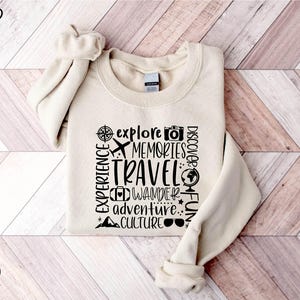 a white sweater with words on it on a wooden floor