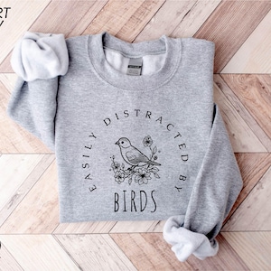 a grey sweatshirt with a bird on it