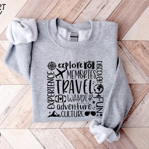 a gray sweatshirt with words on it on a wooden floor